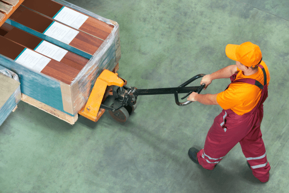 A worker moving a heavy load with a mechanical aid