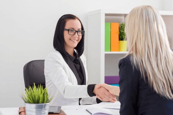 A female manager and female employee shaking hands