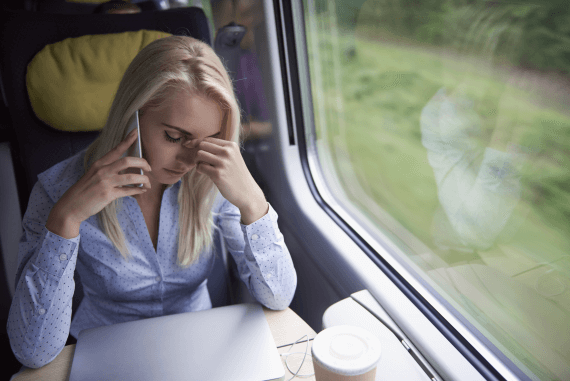 A female worker feeling stressed sat on a train